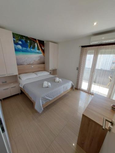 a bedroom with a bed with a painting on the wall at Apartmani Tropical in Vodice