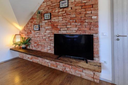 a brick wall with a large flat screen tv at ABC apartments in Kamnik