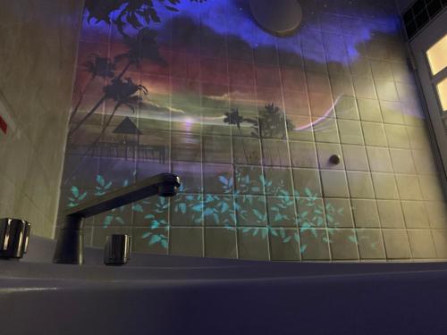 ein Badezimmer mit einem Waschbecken und einer gefliesten Wand in der Unterkunft ホテル　モモ 