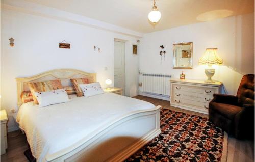 sypialnia z dużym białym łóżkiem i krzesłem w obiekcie Lovely Home In Flacheres With Kitchenette w mieście Flachères