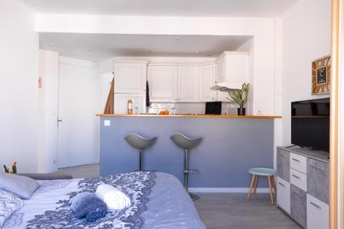 une chambre avec un lit bleu et une cuisine dans l'établissement Cannes centre apartment with a balcony, à Cannes