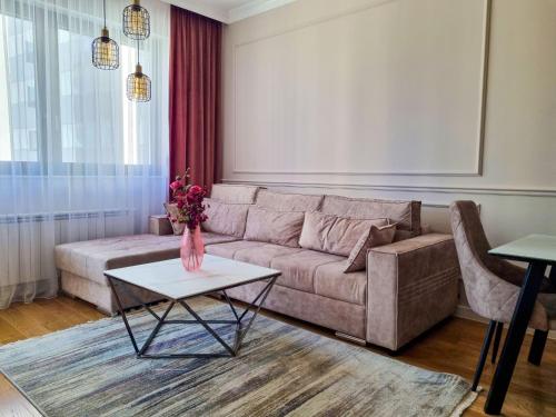 Comfort Lux Residence في بانيا لوكا: غرفة معيشة مع أريكة وطاولة