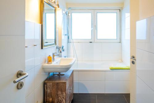 La salle de bains est pourvue d'un lavabo, d'une baignoire et de fenêtres. dans l'établissement Art City-Studios Kassel 4 und 8, groß, modern, citynah, je 3 Schlafzimmer, kostenfreie Parkplätze, Süd-Balkons, ruhig, Herkulesblick, à Cassel