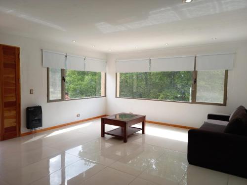 sala de estar con mesa y 2 ventanas en Sueños de Montaña en Villa Yacanto