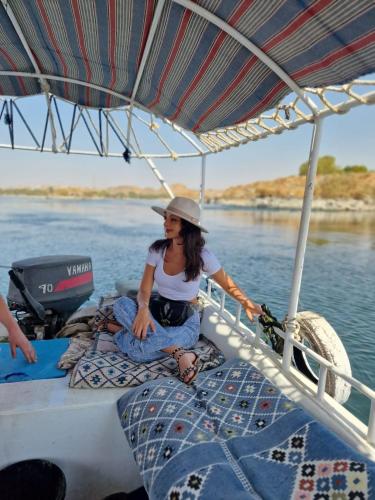 a woman sitting on a boat in the water at Fenti Nubian Resort in Aswan