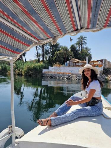 a woman sitting on a boat with a teddy bear at Fenti Nubian Resort in Aswan