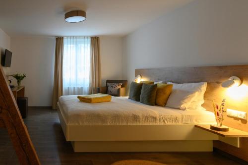 Un dormitorio con una cama grande y una ventana en Adler Schiltach Boutique Hotel und Restaurant, en Schiltach
