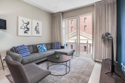 a living room with a couch and a table at Urban Oasis Apartments at Tyrwhitt in Johannesburg