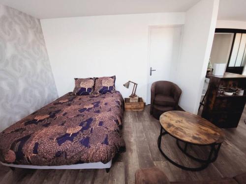a bedroom with a bed and a table and a chair at Studio tout confort in Blaye-les-Mines