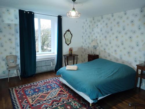 Un dormitorio con una cama azul y una ventana en Chambres d'hôtes proche d'Epinal, Vosges 88270, 