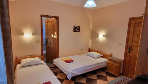 a small room with two beds and a doorway at Amfora Guest House in Byala