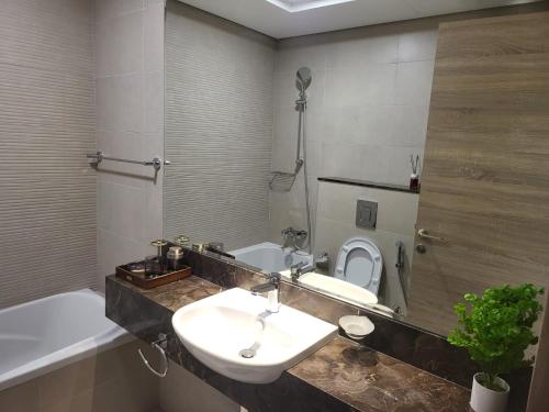 La salle de bains est pourvue d'un lavabo, de toilettes et d'une baignoire. dans l'établissement FULLY FURNISHED 2BR APARTMENT WITH MAIDS ROOM B411, à Dubaï
