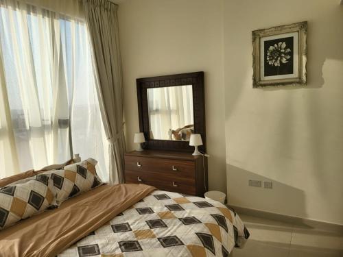 a bedroom with a bed with a mirror and a dresser at FULLY FURNISHED 2BR APARTMENT WITH MAIDS ROOM B411 in Dubai