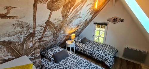 - une chambre avec 2 lits et un mur orné d'une fresque murale dans l'établissement Maison normande, à Freneuse-sur-Risle