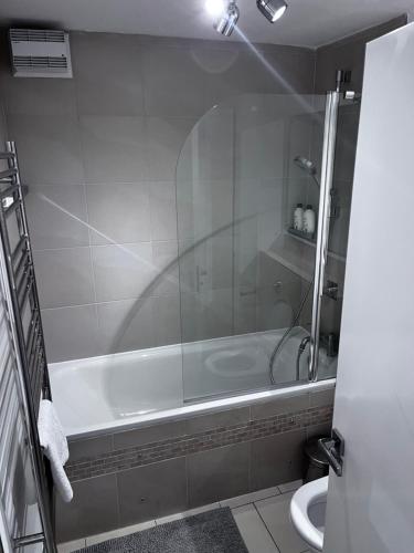 a bathroom with a shower and a tub and a toilet at Hyde Park,3 min walk,Family home! 2 Bedrooms & 2 Bathrooms Apartment! Fantastic Location in London