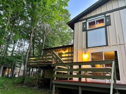 a house with a large deck next to some trees at The Lakeside Eagle's Nest Near the Trail in Hurley