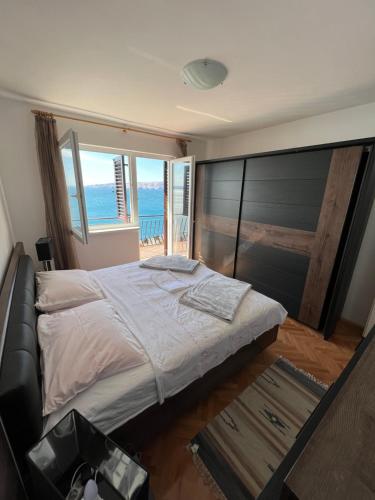 Schlafzimmer mit einem großen Bett und Meerblick in der Unterkunft Apartment Ivanka in Senj