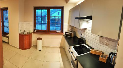 a kitchen with a sink and a stove in it at Villa Krasnowolska Airport - Self Check-in in Warsaw