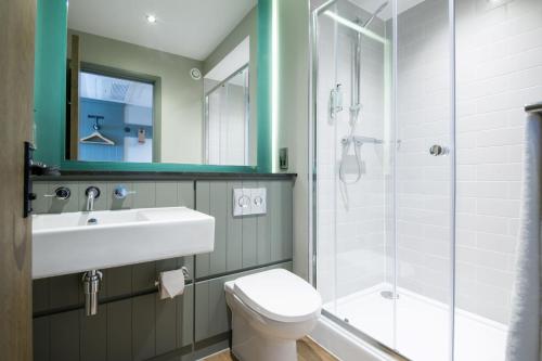 uma casa de banho com um WC, um lavatório e um chuveiro em The Melville Inn by Innkeeper's Collection em Dalkeith