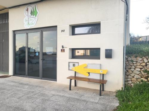 a building with a bench in front of it at Los Tres Abetos in Arzúa