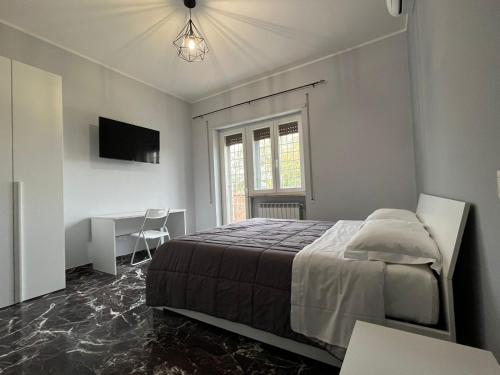 Dormitorio con cama, escritorio y TV en VillaRussoRoma, en Roma