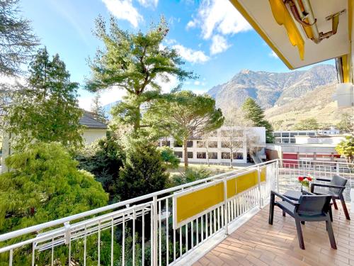 d'un balcon avec une table, des chaises et des montagnes. dans l'établissement Villa Sabine, à Merano