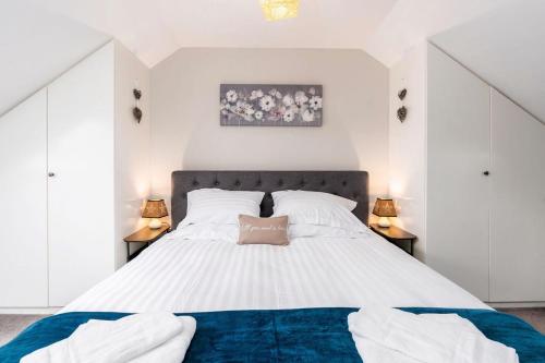 Stunning 3BD Home Hillsborough Sheffield في شيفيلد: غرفة نوم بسرير ابيض كبير ومصباحين