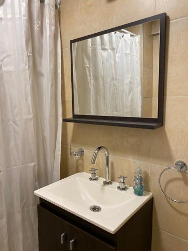 Piso exclusivo en excelente ubicación في روزاريو: حمام مع حوض ومرآة