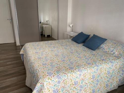 1 dormitorio con 1 cama grande con almohadas azules en Piso exclusivo en excelente ubicación en Rosario