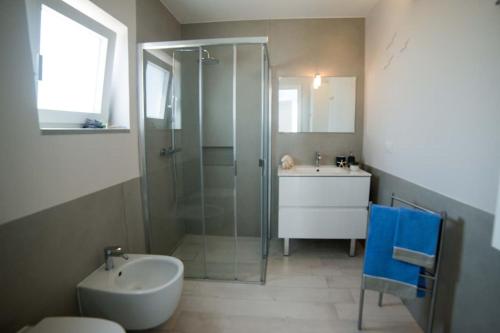 トッレ・サン・ジョヴァンニ・ウジェントにあるAppartamento Mare Verdeのバスルーム(ガラス張りのシャワー、シンク付)