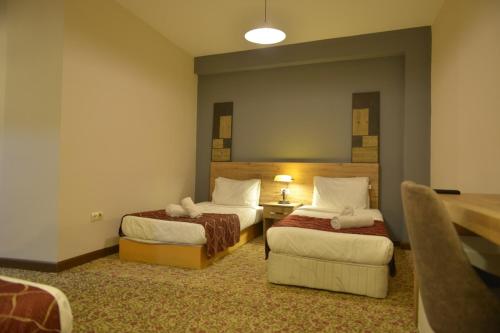 una habitación de hotel con 2 camas y una silla en bolu old town guest house, en Bolu