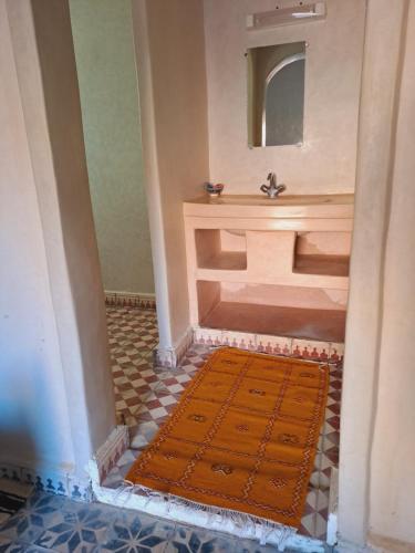 a bathroom with a sink and a rug on the floor at Riad Assia Foum Zguid in Foum Zguid