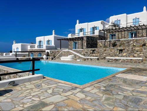 a villa with a swimming pool in front of a building at Mykonos Dot - The Villas in Mikonos