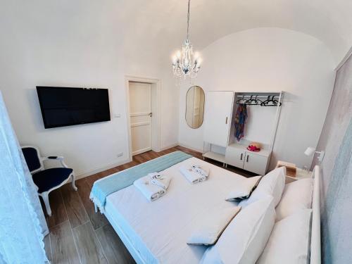 a white bedroom with a bed and a tv at Fiori d'Arancio in Terrasini