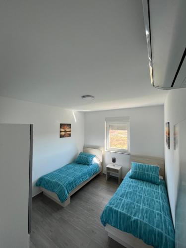 - une chambre avec 2 lits et une fenêtre dans l'établissement Apartman - Kera Nin, à Nin