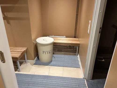a hallway with a trash can and a bench at Hotel Lapuahovi in Lapua