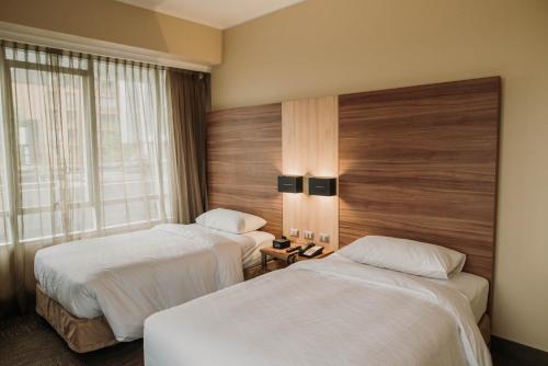 um quarto de hotel com duas camas e uma janela em Mercure Concepcion em Concepción
