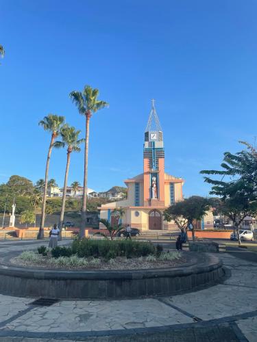 a building with a clock tower and palm trees at Ti Kaz'ETA in Sainte-Anne
