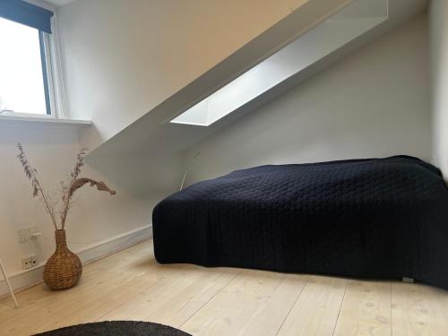 um quarto com uma cama preta e uma janela em New Yorker lejlighed em Aarhus
