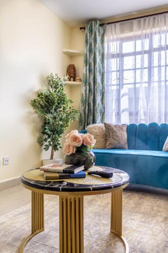 a living room with a blue couch and a table at Quzuri Homestay nearJKIA SGR NRB Kenya in Syokimau