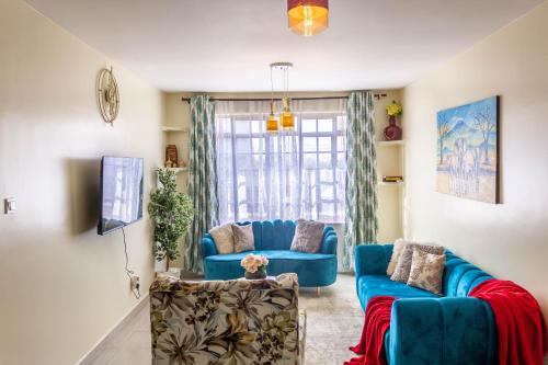 a living room with two blue couches and a window at Quzuri Homestay nearJKIA SGR NRB Kenya in Syokimau