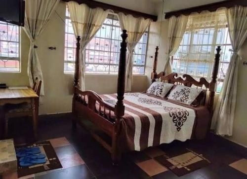 ein Schlafzimmer mit einem großen Bett mit einem Holzrahmen in der Unterkunft Kakamega Town Guest House in Kakamega