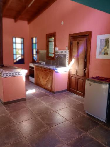 a kitchen with a counter and a refrigerator in a room at La casita del bosque, en el río. in Fray Luis Beltrán