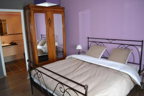a bedroom with a large bed and a mirror at La Villa de Jeanne in Les Riceys