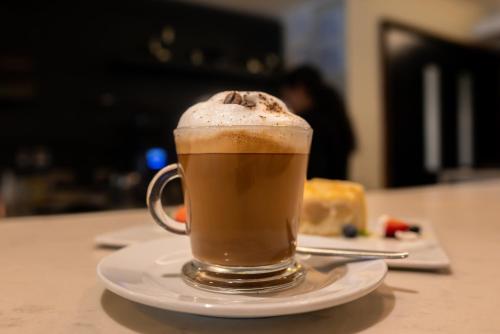 una taza de café en un plato en una mesa en Mercure Concepcion, en Concepción