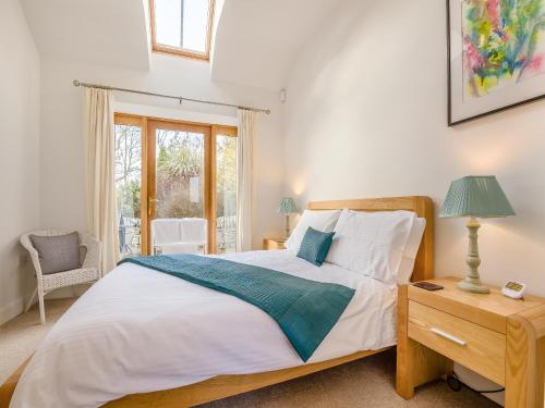 1 dormitorio con 1 cama y 1 mesa con lámpara en The Old Stables en Kirkton of Tealing