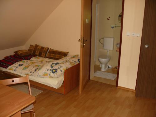 a small bedroom with a bed and a toilet at Pokoje Gościnne POD KNOTEM in Karwieńskie Błoto Drugie
