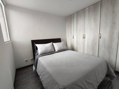 a bedroom with a large bed and a cabinet at Apartamento embajada americana in Bogotá