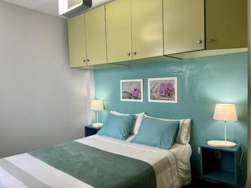 a bedroom with a bed with blue walls and cabinets at Estudios Dalia in Vecindario