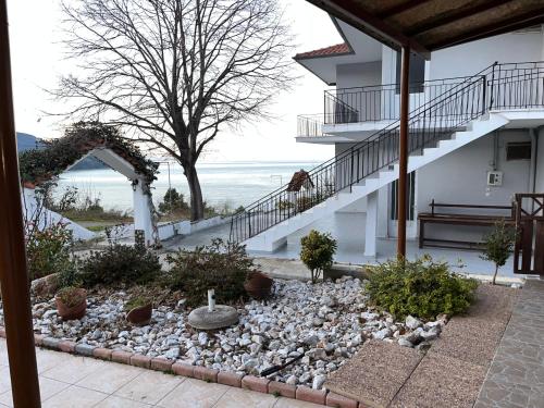 a rock garden in front of a house with a staircase at Villa Leonidas KOUTSOUPIA in Kókkinon Nerón